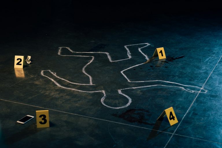 chalk outline and evidence markers at crime scene