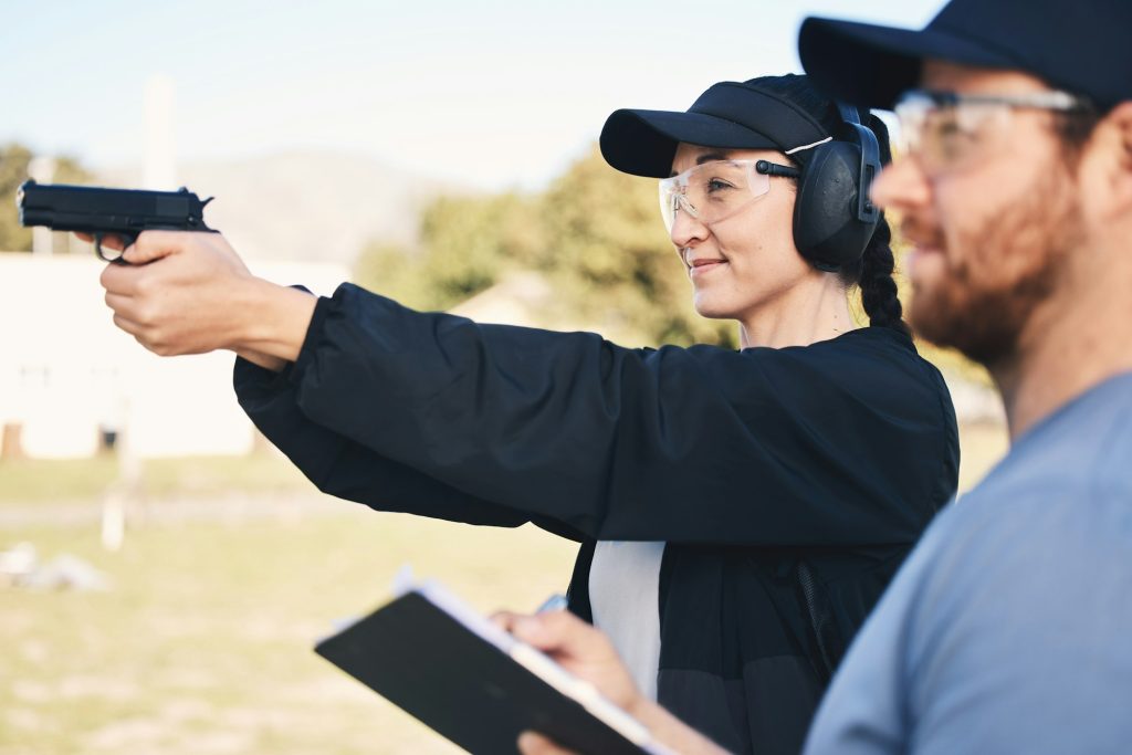 Gun range, target practice and woman holding a rifle for safety, security and police training. Fiel